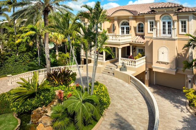 69 Cannon Royal Dr, Shark Key, FL 33040 - mediterranean / spanish-style house featuring stucco siding, a balcony, driveway, and a tiled roof