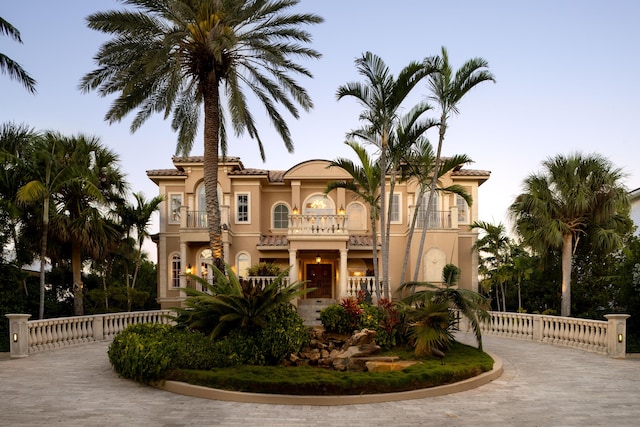 69 Cannon Royal Dr, Shark Key, FL 33040 - mediterranean / spanish-style home featuring a tile roof, a balcony, curved driveway, and stucco siding