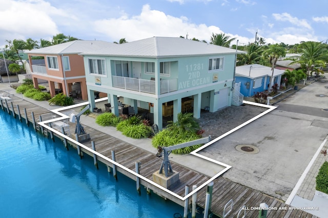 rear view of house featuring a balcony and a water view