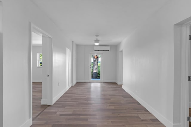 corridor featuring wood-type flooring and a wall mounted AC