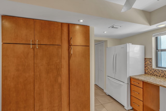 601 W Ocean Dr Unit 414D, Key Colony, FL 33051 - kitchen featuring freestanding refrigerator, light tile patterned flooring, recessed lighting, light stone counters, and brown cabinets