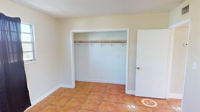 unfurnished bedroom featuring light tile patterned floors and a closet