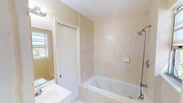 bathroom featuring tiled shower / bath combo and sink