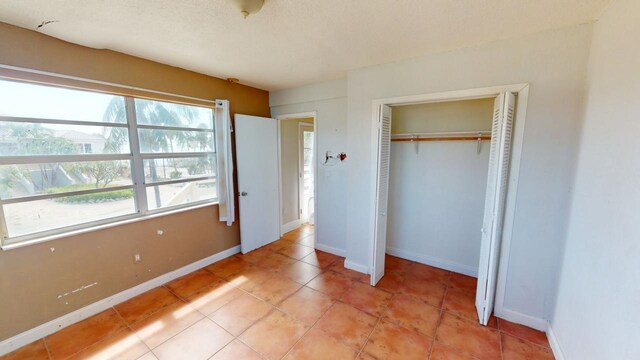 unfurnished bedroom with a closet and light tile patterned flooring