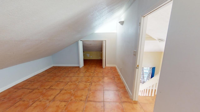 bonus room featuring light tile patterned floors, vaulted ceiling, and a textured ceiling