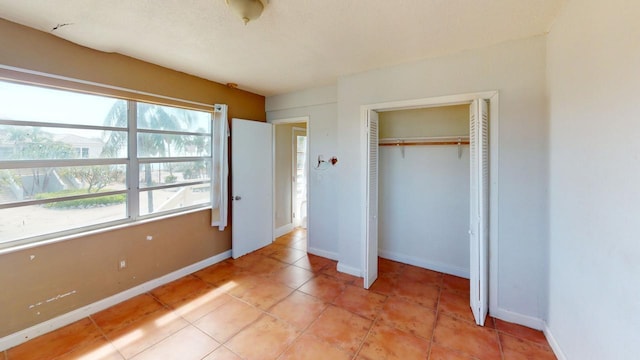 unfurnished bedroom with a closet and light tile patterned floors