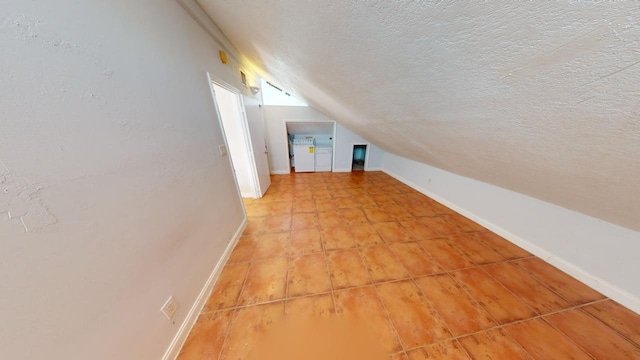 bonus room with lofted ceiling and a textured ceiling