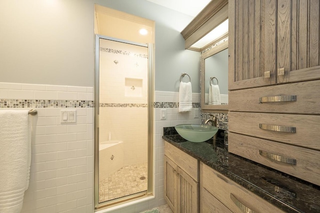 bathroom with vanity, an enclosed shower, and tile walls