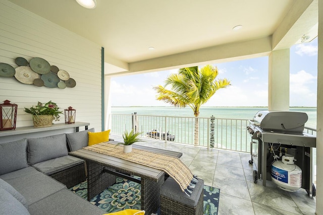 view of patio / terrace featuring an outdoor living space, a balcony, a grill, and a water view