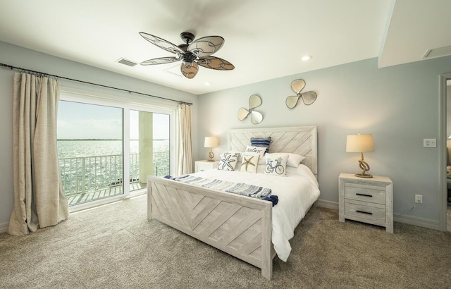 carpeted bedroom with ceiling fan and a water view