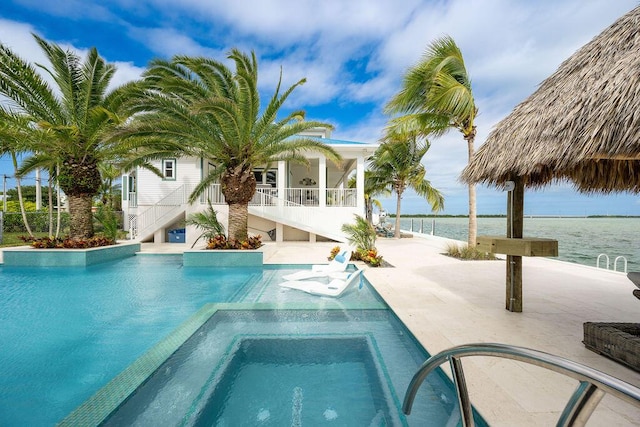 view of swimming pool featuring an in ground hot tub, a sunroom, a patio, and a water view