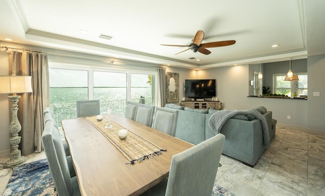 dining area featuring a raised ceiling, ornamental molding, a wealth of natural light, and ceiling fan