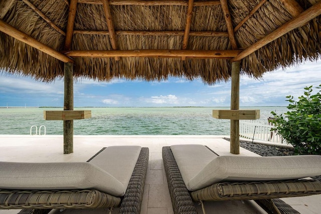 view of swimming pool with a gazebo, a water view, and a beach view