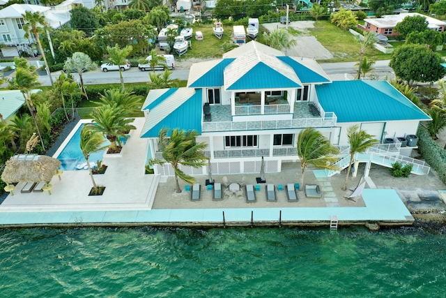 rear view of house with a balcony and a water view