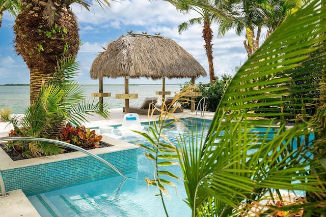 view of swimming pool with a gazebo, a water view, and a hot tub