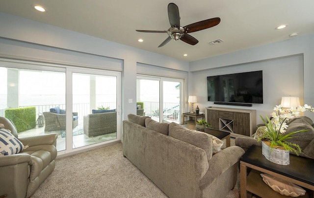 carpeted living room featuring ceiling fan