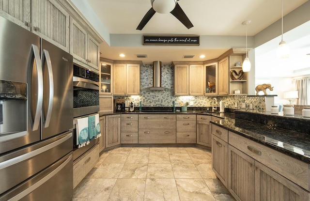 kitchen with wall chimney range hood, dark stone countertops, backsplash, stainless steel appliances, and decorative light fixtures