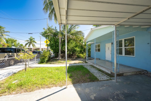 view of yard featuring fence and covered porch