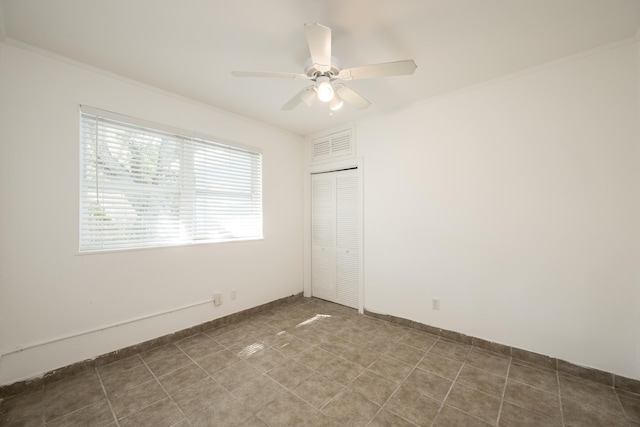 unfurnished bedroom featuring ceiling fan, visible vents, crown molding, baseboards, and a closet