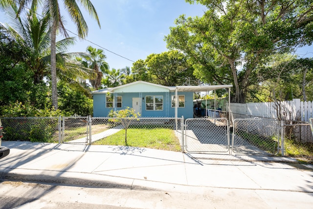 view of front of house featuring driveway, a fenced front yard, a gate, and an attached carport