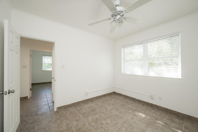 unfurnished room with a ceiling fan, baseboards, ornamental molding, and light tile patterned floors