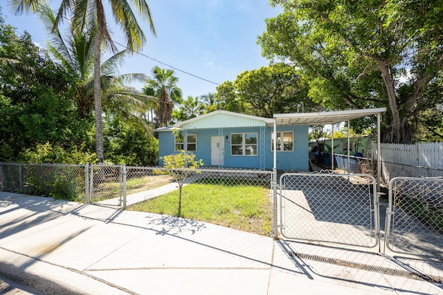 bungalow-style house featuring a front lawn, a fenced front yard, a gate, and a carport