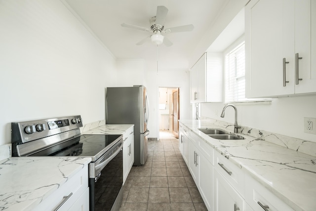 kitchen with appliances with stainless steel finishes, light stone counters, a sink, a ceiling fan, and white cabinetry