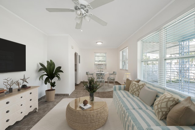 living room featuring crown molding, ceiling fan, baseboards, and tile patterned floors