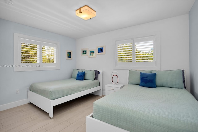 30 Ocean Front Dr, Key Largo, FL 33037 - bedroom featuring multiple windows and light hardwood / wood-style floors