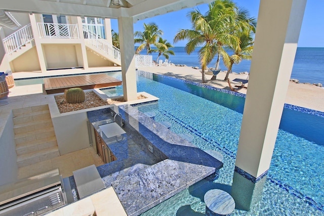 30 Ocean Front Dr, Key Largo, FL 33037 - view of swimming pool featuring exterior kitchen, a wet bar, and a water view