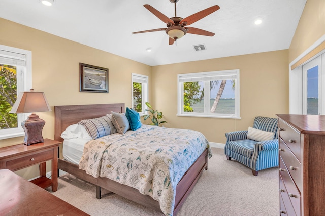 bedroom featuring vaulted ceiling, light carpet, and ceiling fan