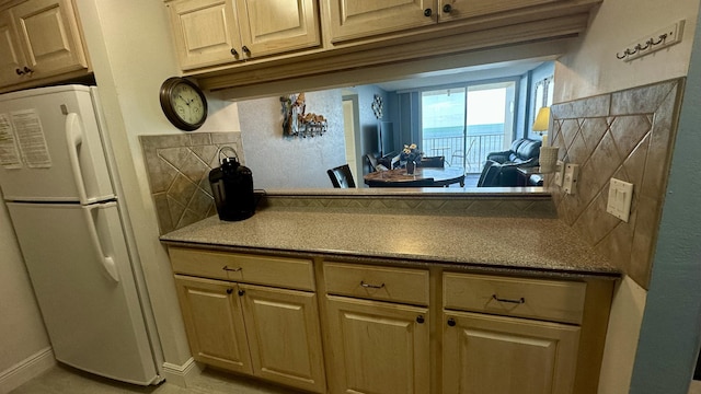 kitchen featuring white refrigerator and tasteful backsplash