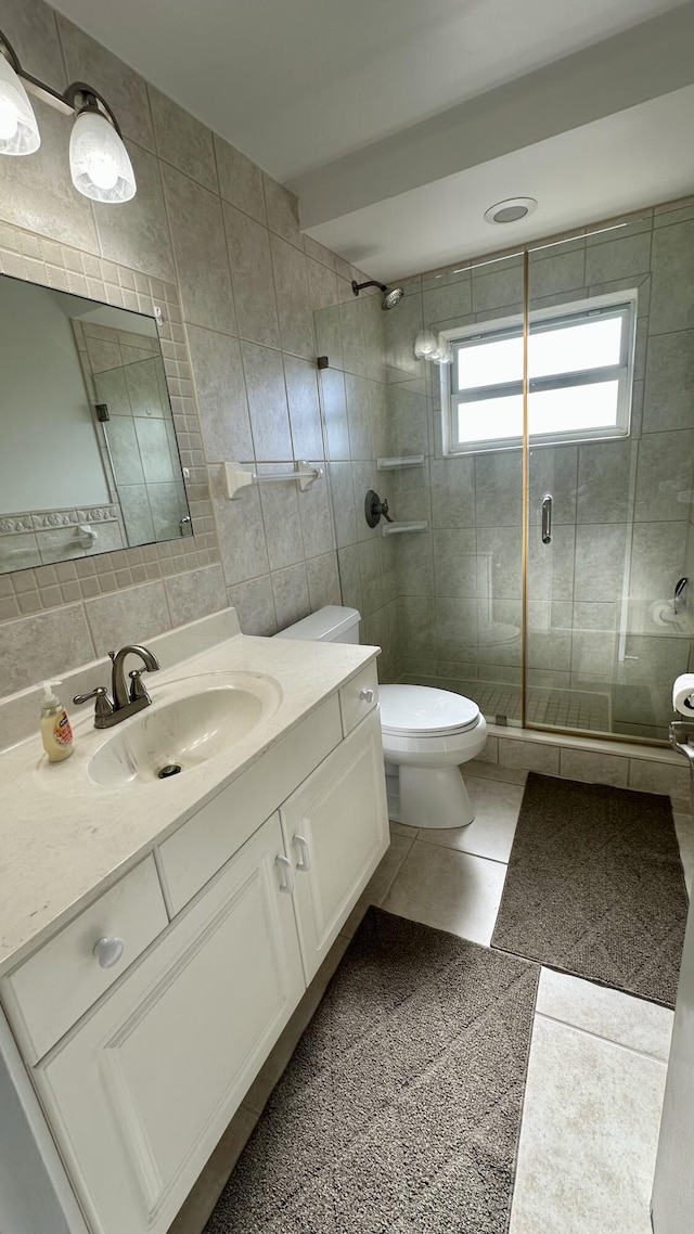 bathroom with tasteful backsplash, vanity, an enclosed shower, and tile walls