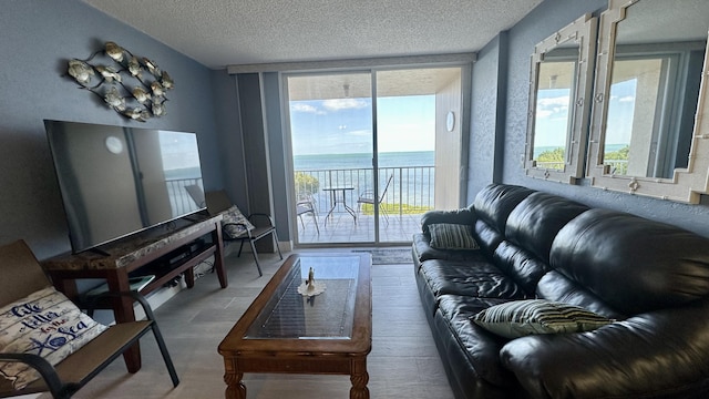 living room with hardwood / wood-style flooring, plenty of natural light, floor to ceiling windows, and a water view