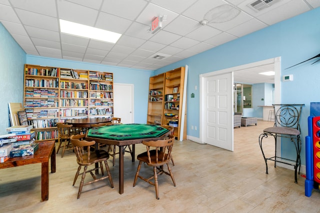 game room with a paneled ceiling and light hardwood / wood-style floors