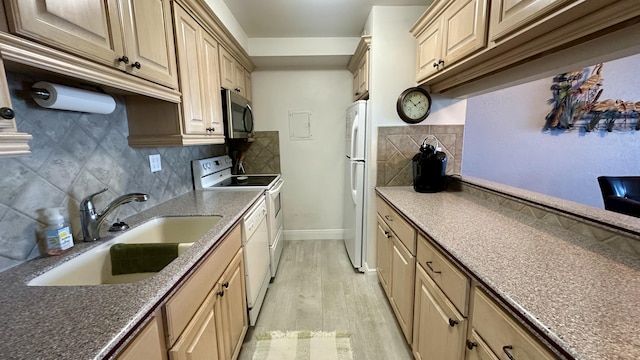 kitchen featuring sink, white appliances, light hardwood / wood-style flooring, light brown cabinetry, and decorative backsplash