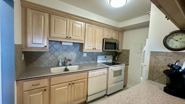 kitchen featuring white appliances, light brown cabinetry, sink, and backsplash