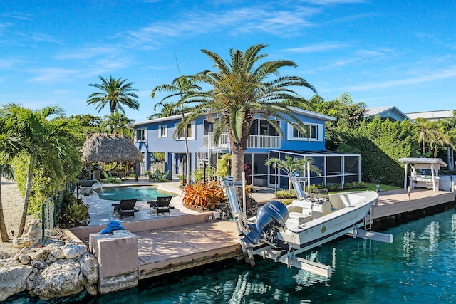 view of dock featuring a water view, a balcony, a patio area, and pool water feature