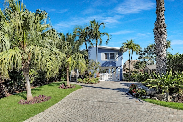 beach home featuring a front lawn and a carport