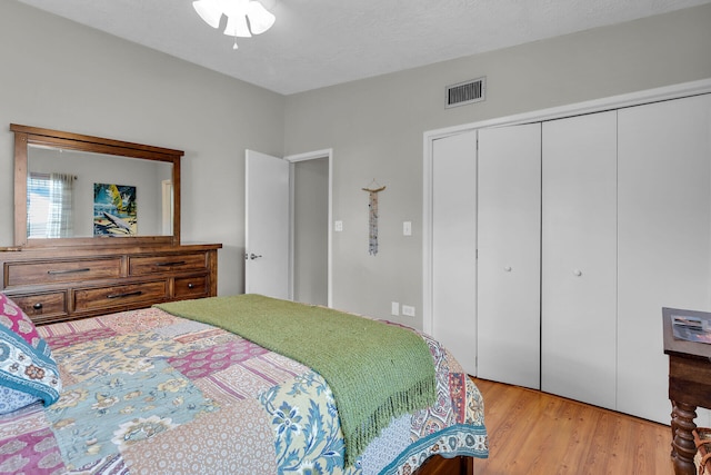 bedroom featuring a closet, a textured ceiling, and light wood-type flooring