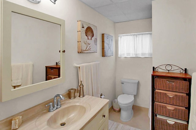 bathroom featuring a paneled ceiling, vanity, and toilet