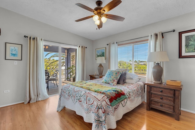 bedroom with access to outside, light hardwood / wood-style floors, and a textured ceiling