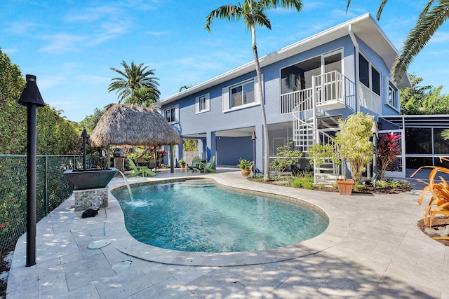 view of swimming pool with a gazebo, a sunroom, and a patio