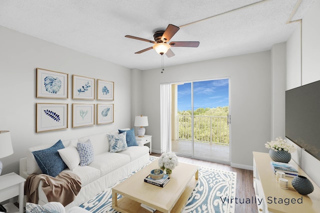 living room featuring hardwood / wood-style floors, a textured ceiling, and ceiling fan