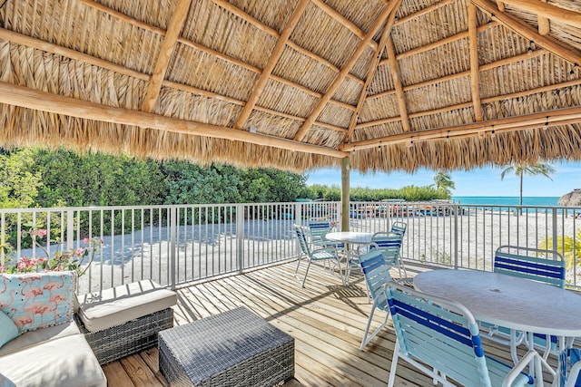 wooden terrace with a gazebo, a beach view, and a water view