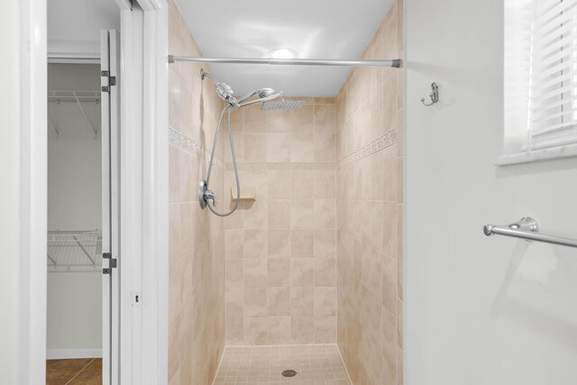 bathroom with tile patterned flooring and tiled shower