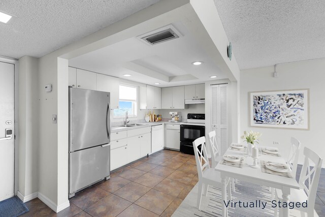 kitchen featuring stainless steel refrigerator, sink, white cabinets, a textured ceiling, and electric stove