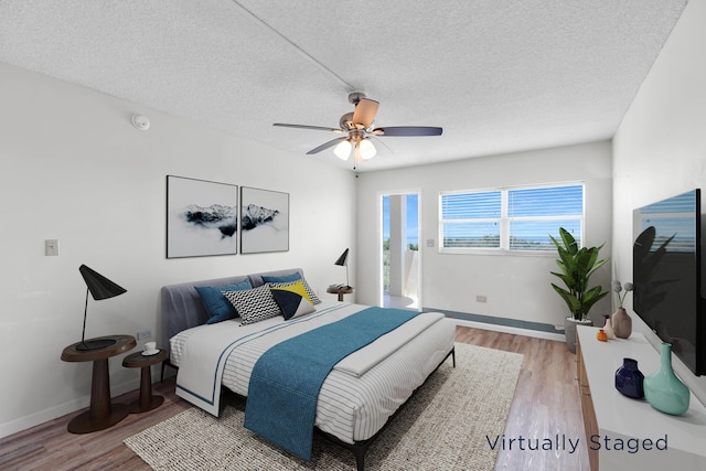 bedroom featuring ceiling fan, hardwood / wood-style flooring, and a textured ceiling