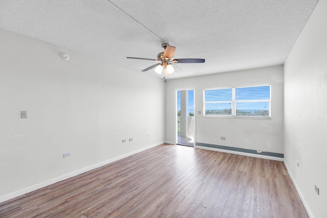 empty room with ceiling fan, light hardwood / wood-style flooring, and a textured ceiling