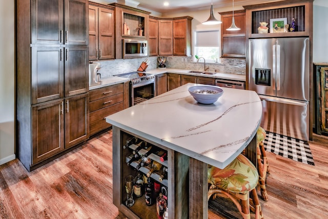 kitchen featuring light wood-style flooring, a sink, appliances with stainless steel finishes, open shelves, and tasteful backsplash